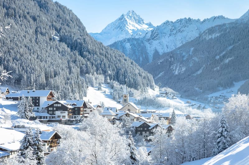 Gaschurn im Winter mit Kirchturm und Bergen